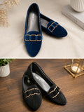 A pair of women's pointed-toe flats shown in two color variants: navy blue suede with gold-tone chain hardware, and black suede with matching gold-tone hardware. The top image shows the navy pair on a light beige textured fabric with decorative props, while the bottom image shows the black pair on a dark wood surface.